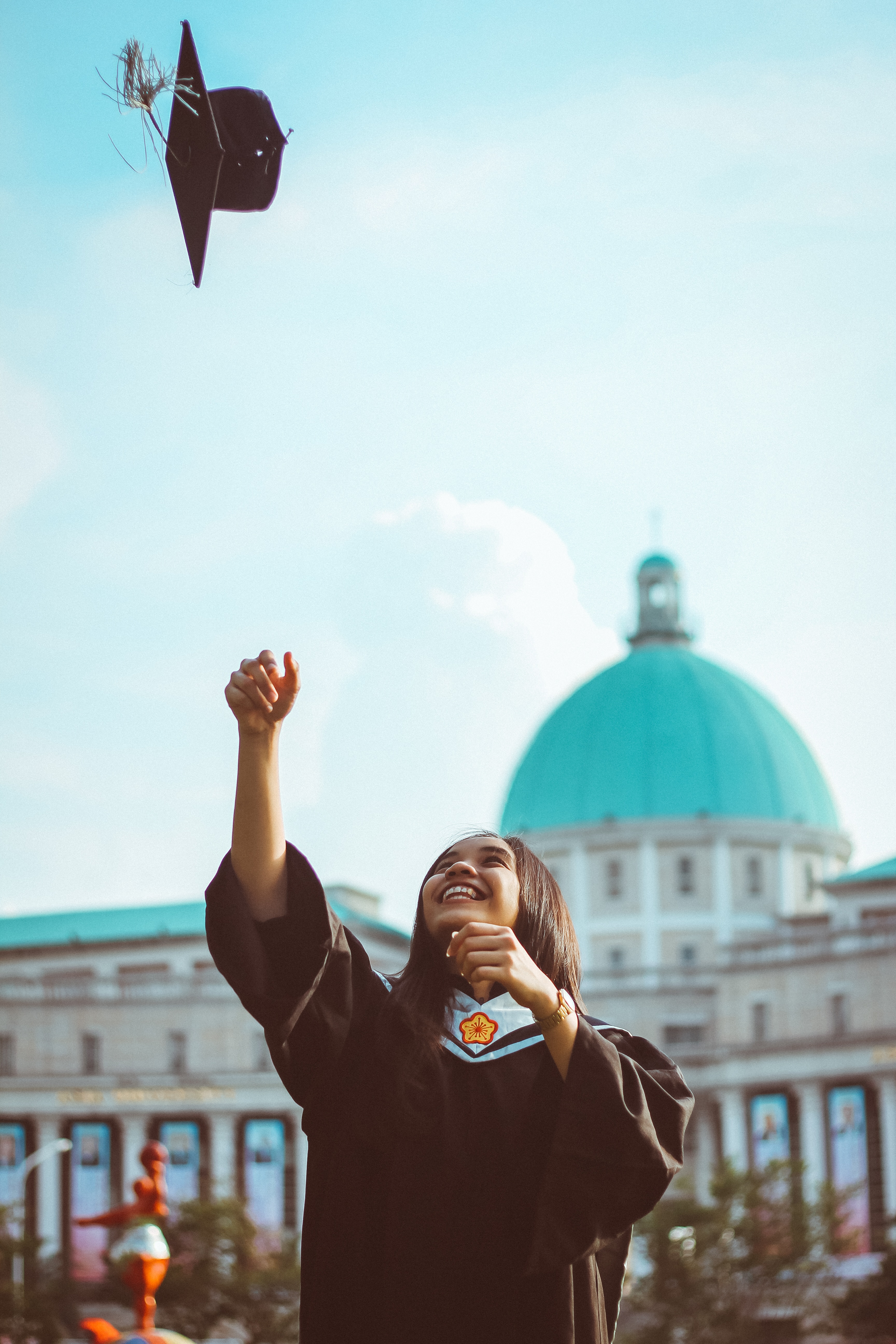 girl throwing cap