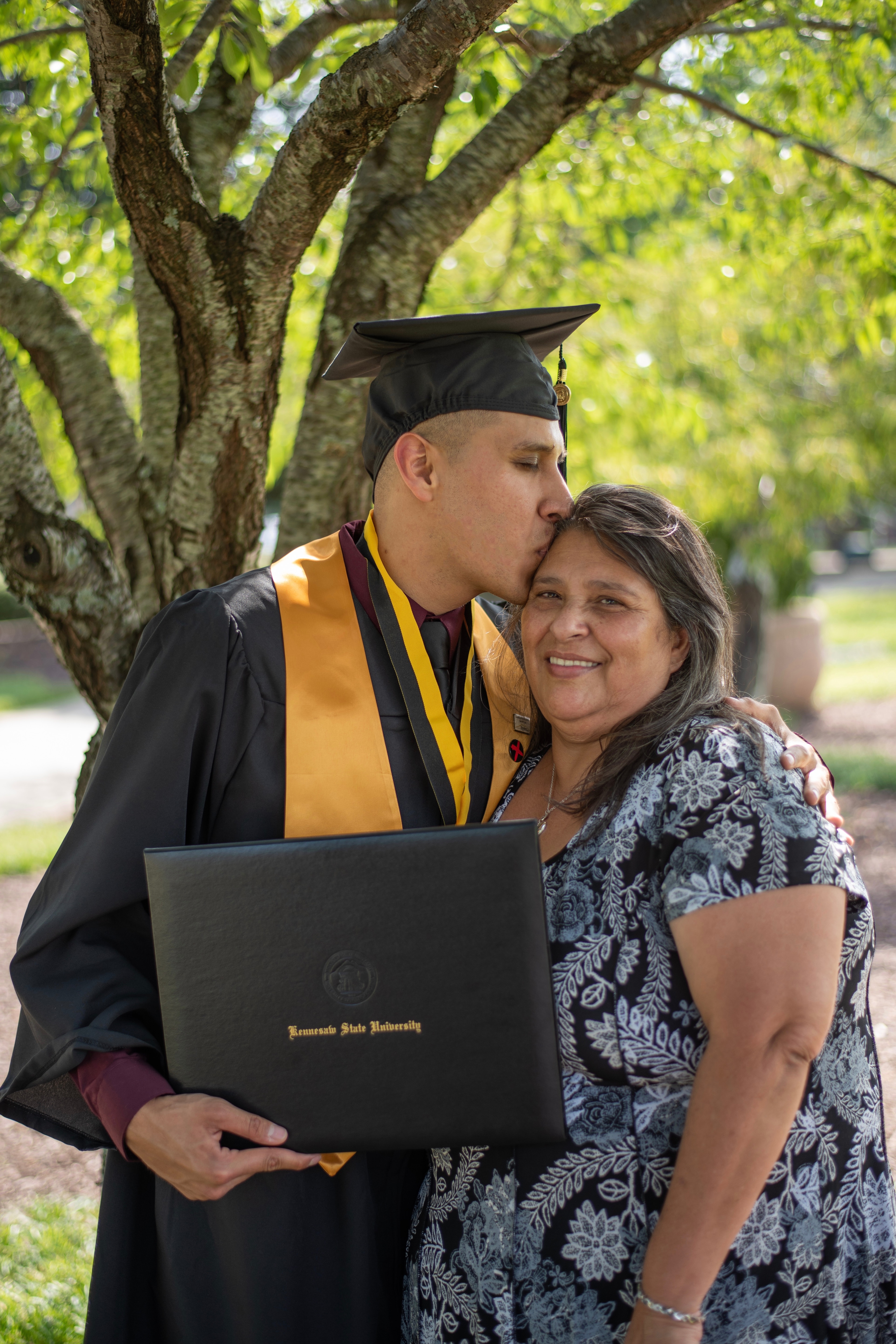 son huging mom after graduation